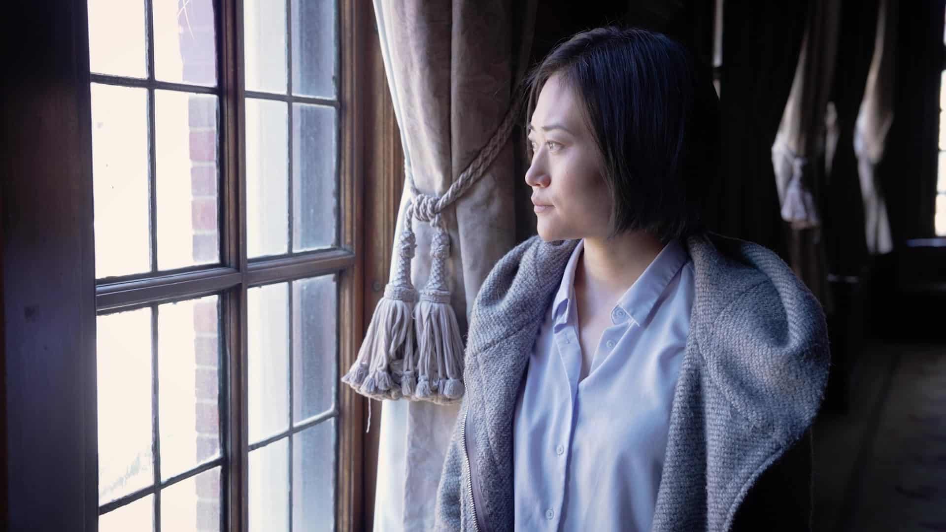Woman looking out of window in Immigrant Stories Public Policy Video for EIG